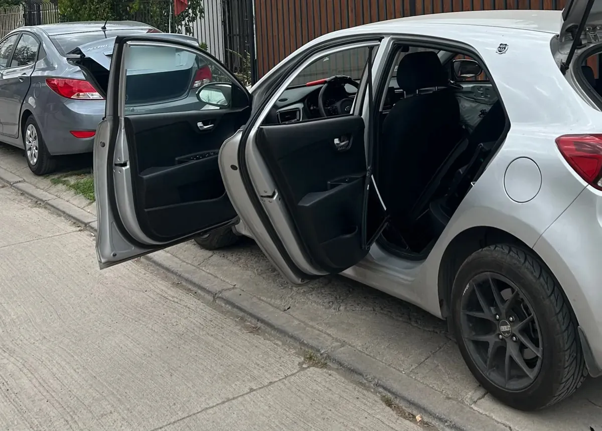 Instalación de lámina de seguridad con las puertas del Kia Rio 5 abiertas, a domicilio en Conchalí