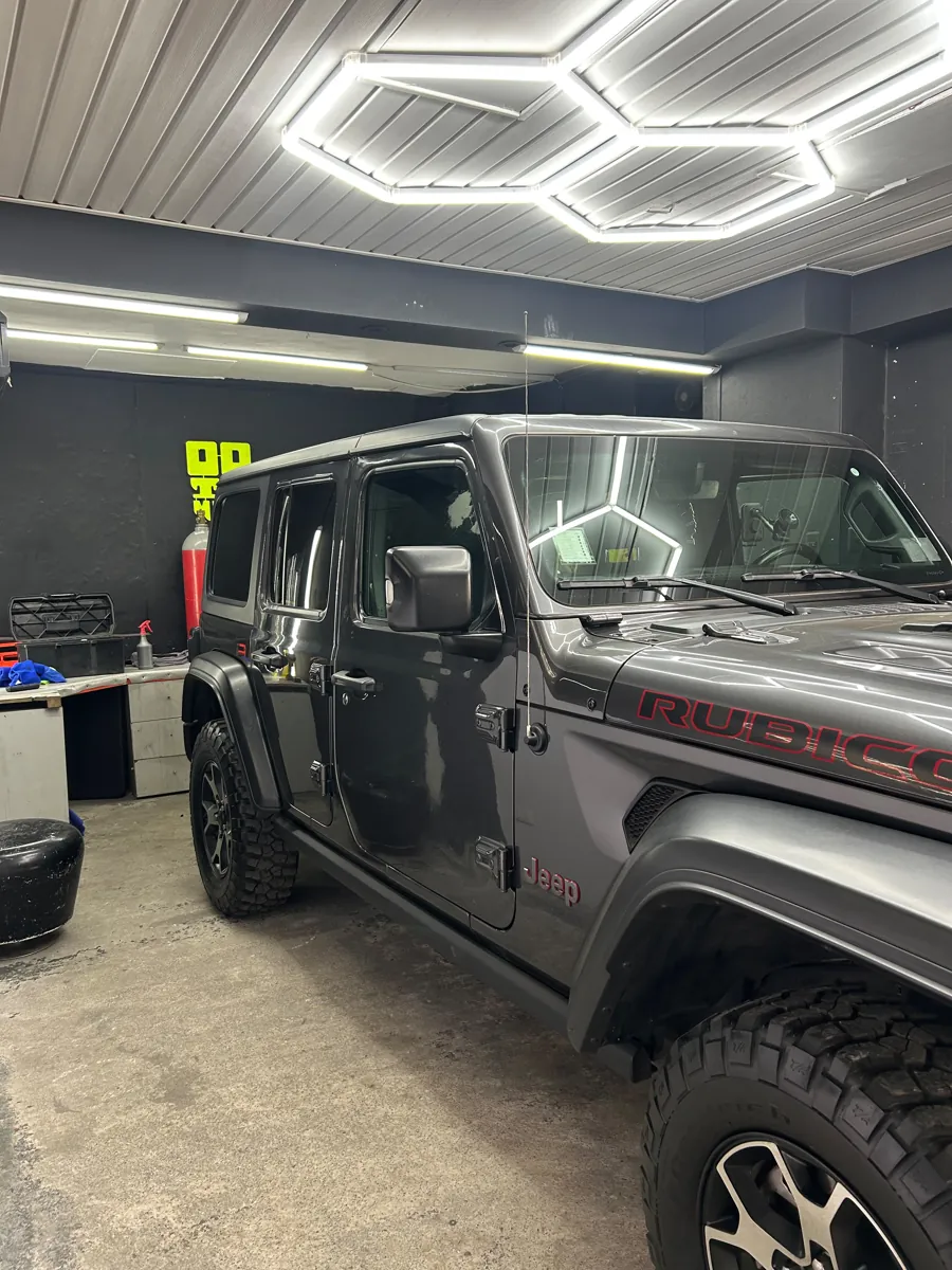 Vista frontal del Jeep Wrangler Rubicon 4x4 con láminas polarizadas en el taller de Santiago