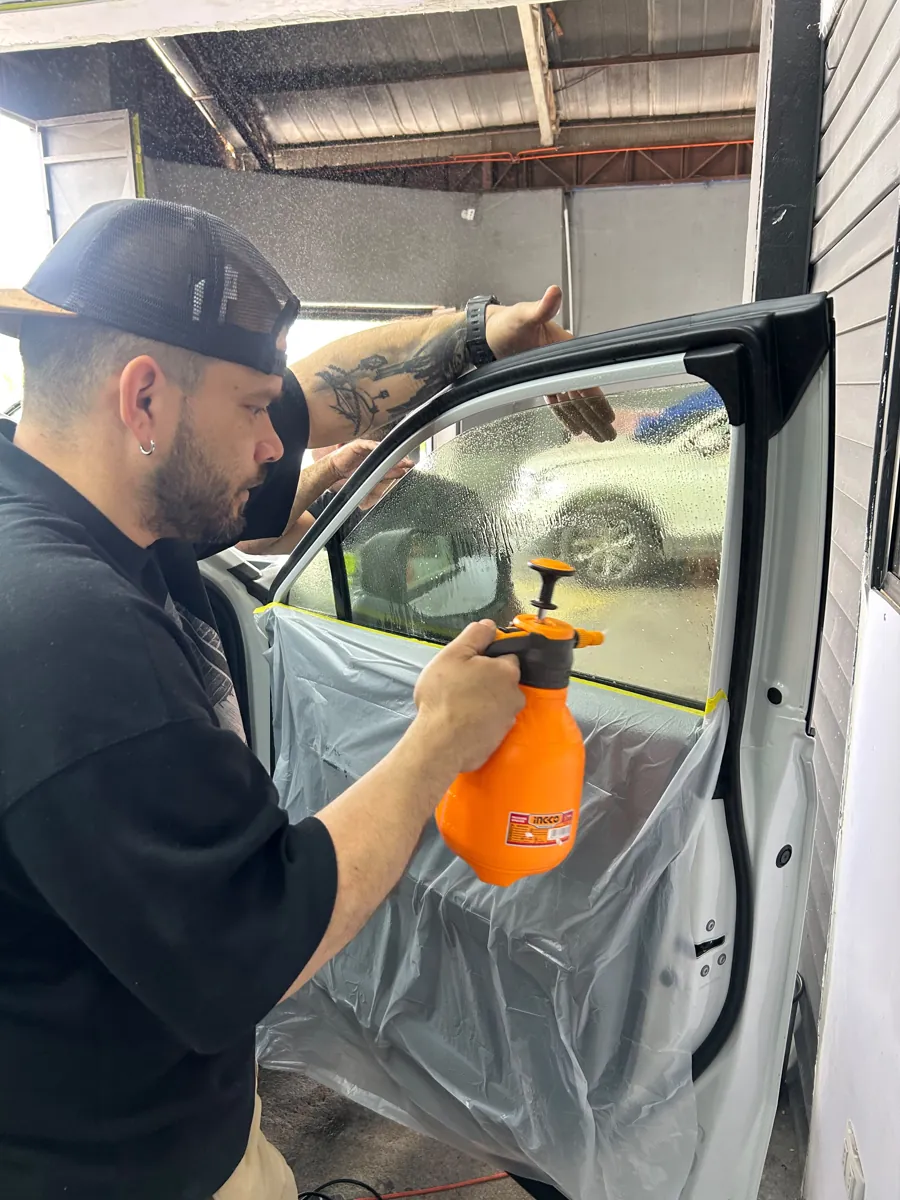 Técnico aplicando la lámina de seguridad en la ventana de la puerta de la Toyota RAV4, Santiago
