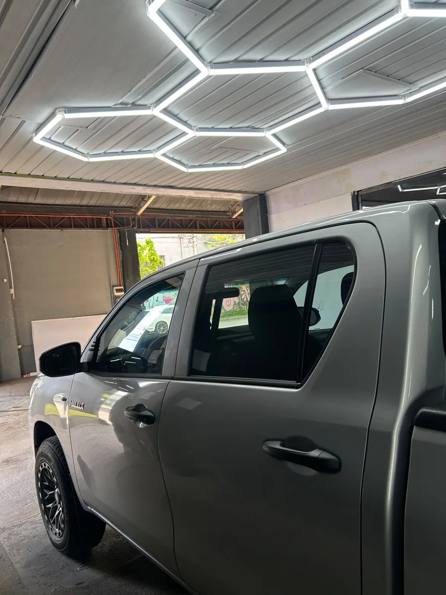 Vista lateral de la Toyota Hilux doble cabina con láminas polarizadas, Santiago
